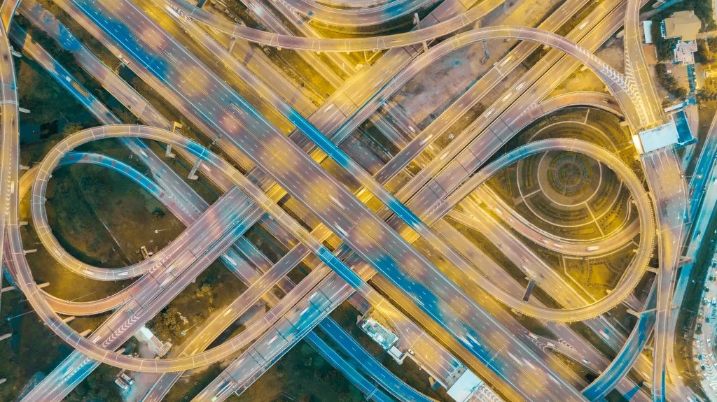 Aerial view of a sprawling multi-level highway interchange, with looping ramps and overpasses routing traffic in every direction.