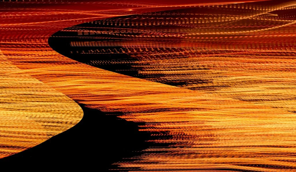 Abstract long-exposure photograph of red and orange light trails forming layered curves around a dark central shape.